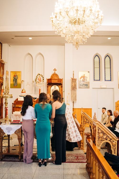 View of church interior with ornate chandelier and religious icons on the walls.