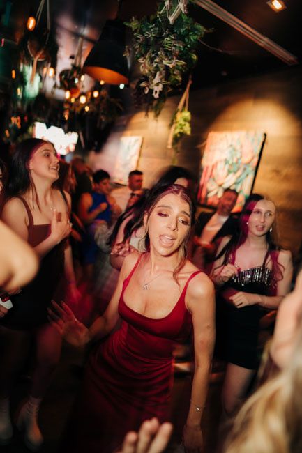 People dancing and enjoying themselves at dimly lit nightclub venue.