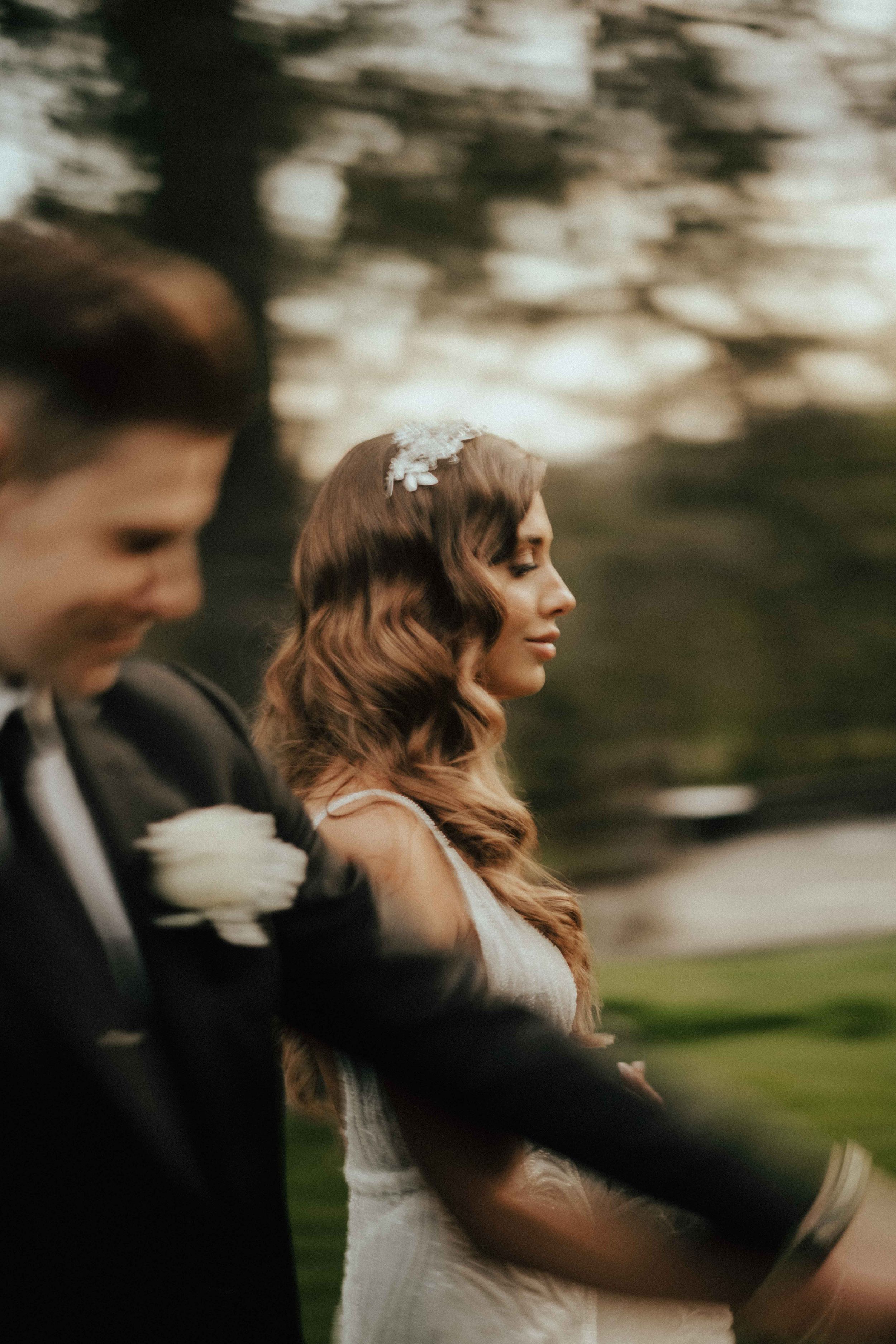 A candid portrait of a bride with her groom beside her.