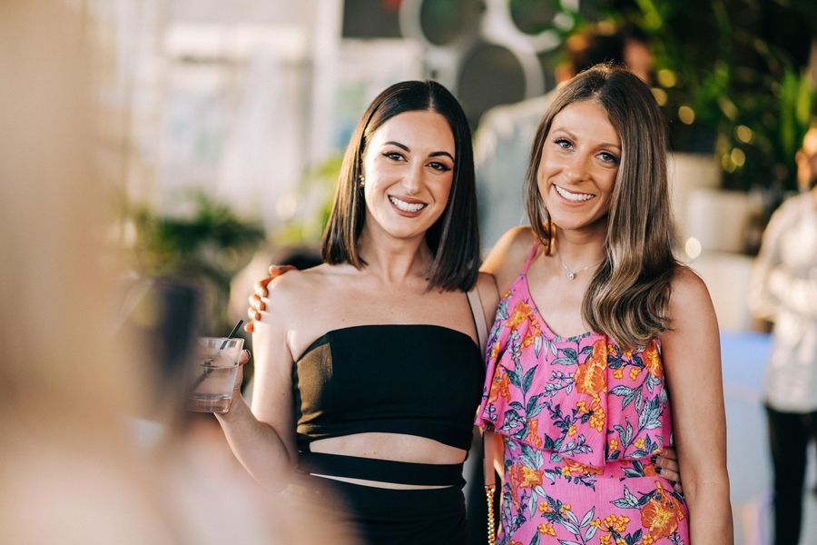 Two friends sharing a joyful moment at an outdoor celebration.