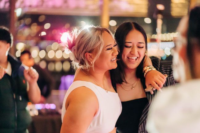 Two guests enjoying themselves at a nighttime celebration with colorful bokeh lights.