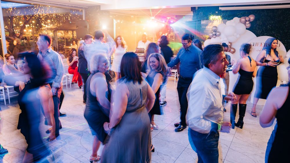 Blurred motion shot of people dancing at evening social event.